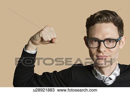 Portrait of a mid adult man flexing muscles over colored background View Large Photo Image Stock Image - Portrait of a mid adult man flexing muscles over colored background. Fotosearch
