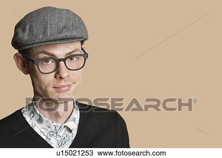 Portrait of a mid adult man wearing retro glasses and cap over colored background View Large Photo Image Stock Image - Portrait of a mid adult man wearing retro glasses and cap over colored background. Fotosearch