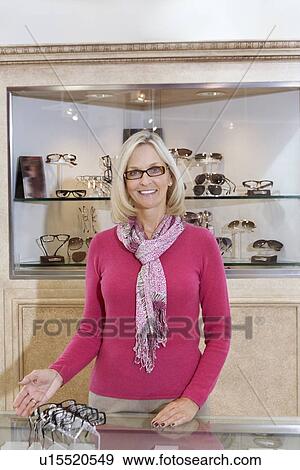 Stock Photo - Portrait of a senior optometrist wearing glasses in store. Fotosearch