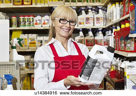 Portrait of a senior woman holding can in retail store View Large Photo Image Stock Photograph - Portrait of a senior woman holding can in retail store. Fotosearch