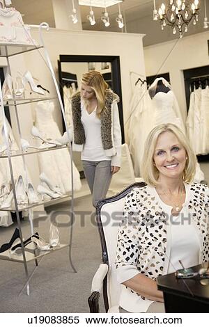 Portrait of a senior woman sitting with young daughter browsing for footwear in background View Large Photo Image Stock Photography - Portrait of a senior woman sitting with young daughter browsing for footwear in background. Fotosearch