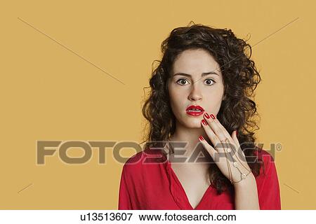 Stock Photo - Portrait of a shocked woman over colored background. Fotosearch
