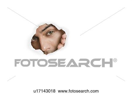 Portrait of a young Asian male peeking from paper hole View Large Photo Image Stock Photo - Portrait of a young Asian male peeking from paper hole. Fotosearch