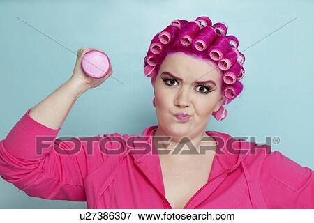 Portrait of a young female lifting dumbbells over colored background View Large Photo Image Stock Photo - Portrait of a young female lifting dumbbells over colored background. Fotosearch