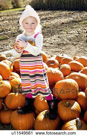 Portrait of a young girl standing on pumpkin View Large Photo Image Stock Image - Portrait of a young girl standing on pumpkin. Fotosearch