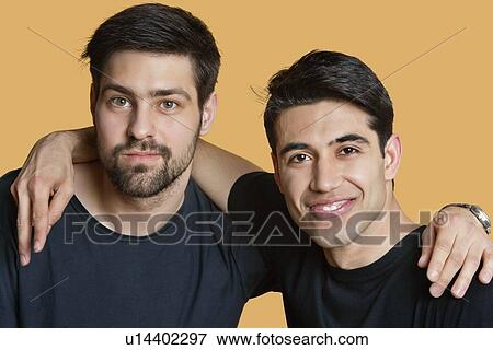 Portrait of a young male friends with arms around over colored background View Large Photo Image Stock Photo - Portrait of a young male friends with arms around over colored background. Fotosearch