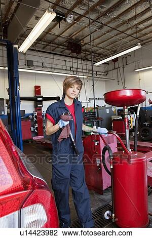 Stock Image - Portrait of a young mechanic standing by welding equipment. Fotosearch