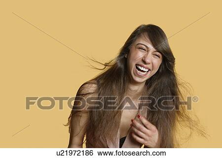 Portrait of a young woman laughing over colored background View Large Photo Image Stock Photograph - Portrait of a young woman laughing over colored background. Fotosearch