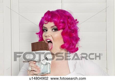 Portrait of a young woman licking chocolate View Large Photo Image Stock Image - Portrait of a young woman licking chocolate. Fotosearch