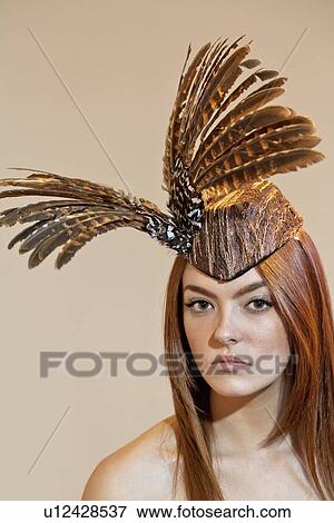 Portrait of a young woman wearing feathered headdress on colored background View Large Photo Image Stock Photo - Portrait of a young woman wearing feathered headdress on colored background. Fotosearch
