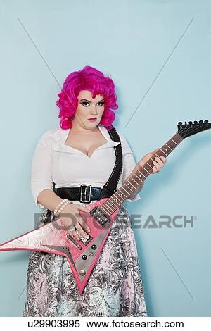 Portrait of a young woman with guitar over colored background View Large Photo Image Stock Photography - Portrait of a young woman with guitar over colored background. Fotosearch
