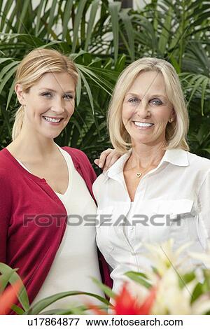 Stock Photo - Portrait of cheerful mother and daughter in garden. Fotosearch