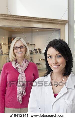 Portrait of happy mid adult optician and customer wearing glasses View Large Photo Image Stock Image - Portrait of happy mid adult optician and customer wearing glasses. Fotosearch
