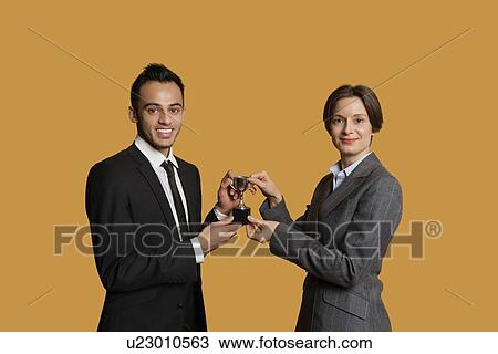 Portrait of happy partners holding winning trophy together View Large Photo Image Stock Image - Portrait of happy partners holding winning trophy together. Fotosearch