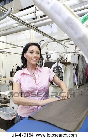 Portrait of happy woman standing by ironing board View Large Photo Image Picture - Portrait of happy woman standing by ironing board. Fotosearch