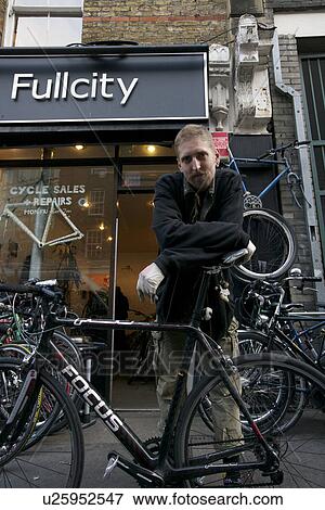 Portrait of mid adult man standing outside cycle shop View Large Photo Image Stock Photo - Portrait of mid adult man standing outside cycle shop. Fotosearch