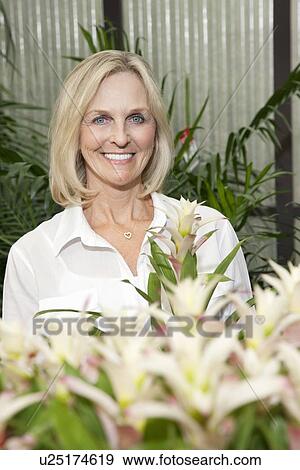 Stock Photo - Portrait of senior woman in greenhouse. Fotosearch