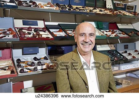 Portrait of tobacco shop owner with pipes in background View Large Photo Image Stock Photograph - Portrait of tobacco shop owner with pipes in background. Fotosearch