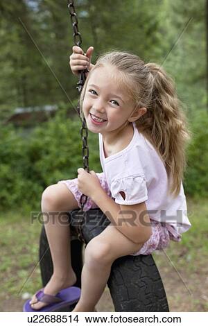 Picture - Portrait of young swinging on tire. Fotosearch