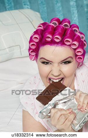 Portrait of young woman eating chocolate bar View Large Photo Image Picture - Portrait of young woman eating chocolate bar. Fotosearch