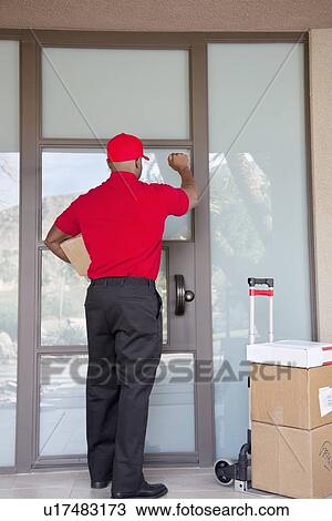 Rear view of a delivery man knocking on door View Large Photo Image Stock Image - Rear view of a delivery man knocking on door. Fotosearch