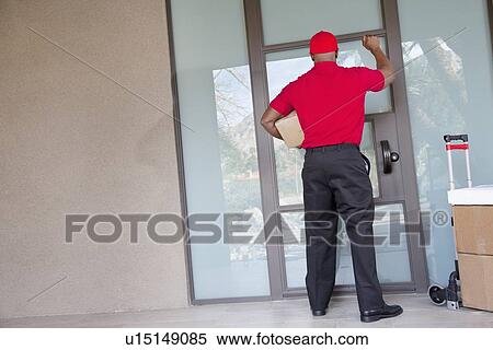Rear view of a delivery man with packages knocking at door View Large Photo Image Stock Photography - Rear view of a delivery man with packages knocking at door. Fotosearch