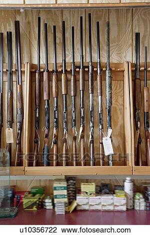 Stock Image - Rifles on display in gun shop. Fotosearch