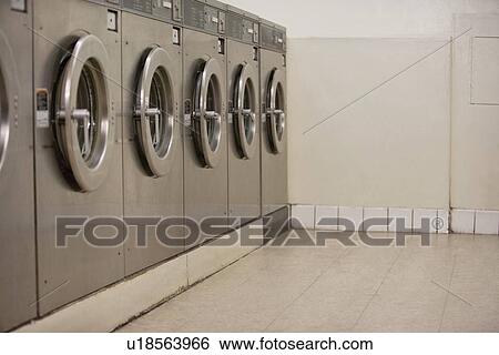 Stock Photograph - Row of self-service clothes dryers in Laundromat. Fotosearch
