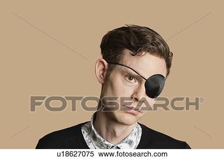 Stock Photography - Sad mid adult man wearing eye patch over colored background. Fotosearch