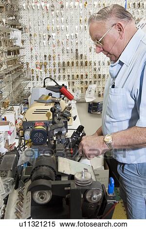 Side view of locksmith working in key store View Large Photo Image Stock Photography - Side view of locksmith working in key store. Fotosearch