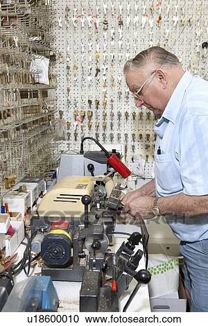 Side view of senior locksmith making key in store View Large Photo Image Stock Image - Side view of senior locksmith making key in store. Fotosearch