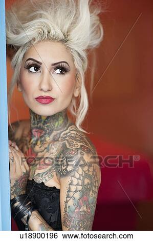 Tattooed young woman looking away View Large Photo Image Stock Photograph - Tattooed young woman looking away. Fotosearch