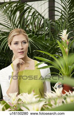 Thoughtful young woman in greenhouse View Large Photo Image Stock Image - Thoughtful young woman in greenhouse. Fotosearch