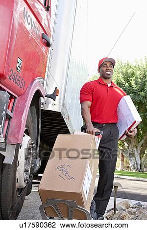 Young African American male standing with packages near delivery truck View Large Photo Image Stock Image - Young African American male standing with packages near delivery truck. Fotosearch