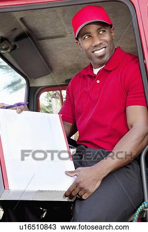 Young African American man sitting in delivery truck with box View Large Photo Image Stock Image - Young African American man sitting in delivery truck with box. Fotosearch