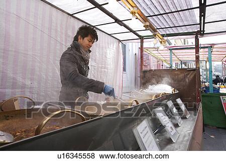 Stock Photo - Young Asian man cooking Thai food. Fotosearch