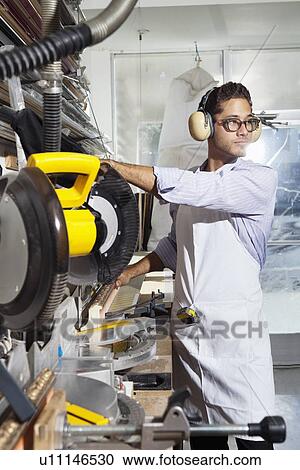 Young craftsman wearing protective gear while using circular saw View Large Photo Image Stock Image - Young craftsman wearing protective gear while using circular saw. Fotosearch