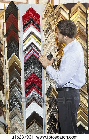 Young man browsing at a frame store View Large Photo Image Stock Image - Young man browsing at a frame store. Fotosearch