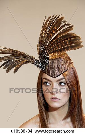Young woman with feathered headgear looking away over colored background View Large Photo Image Picture - Young woman with feathered headgear looking away over colored background. Fotosearch
