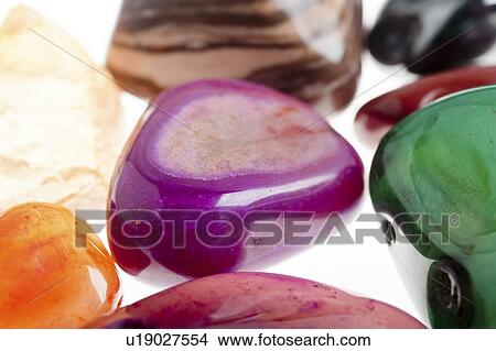 Picture - Assortment of semiprecious gemstones on white background.. Fotosearch