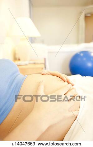 Birthing centre. Close-up of a pregnant woman's abdomen in a room at a birthing centre. View Large Photo Image Stock Photo - Birthing centre. Close-up of a pregnant woman's abdomen in a room at a birthing centre.. Fotosearch