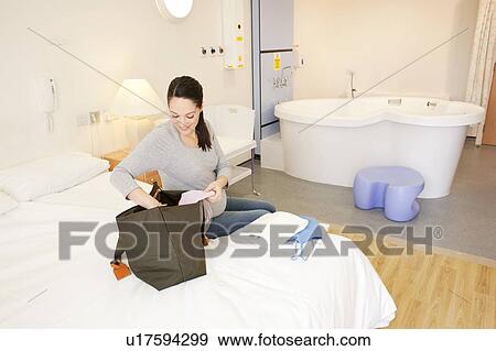 Birthing centre. Pregnant woman unpacking in her room at a birthing centre. View Large Photo Image Stock Photo - Birthing centre. Pregnant woman unpacking in her room at a birthing centre.. Fotosearch