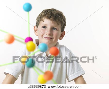 Stock Image - Chemistry lesson. 6 year old boy looking at a molecular structure.. Fotosearch