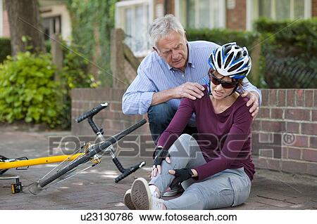 Cycling accident. Man helping a cyclist that has fallen from her bike. View Large Photo Image Stock Photograph - Cycling accident. Man helping a cyclist that has fallen from her bike.. Fotosearch