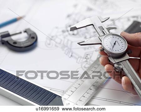 Stock Photo - Engineering. Engineer holding dial calipers.. Fotosearch