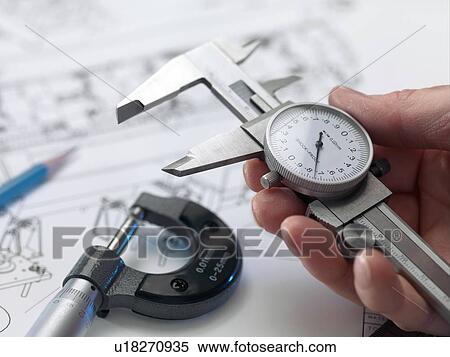 Stock Photography - Engineering. Engineer holding dial calipers.. Fotosearch