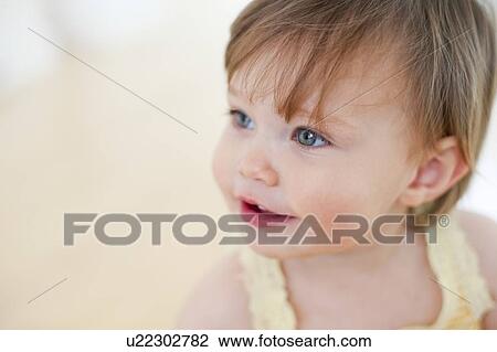 Stock Image - Happy toddler. Smiling 15 month old girl.. Fotosearch
