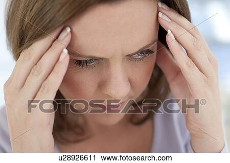 Stock Image - Headache. Woman holding her temples.. Fotosearch