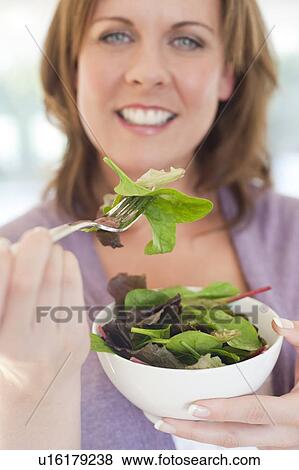 Stock Photo - Healthy eating. Woman eating a salad.. Fotosearch
