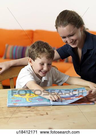 Stock Image - Learning to read. 6 year old boy learning to read.. Fotosearch